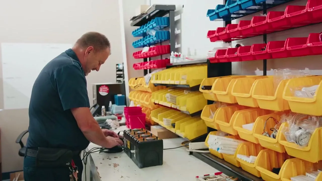 An LSS technician setting up a chemical dispenser at the parts bench